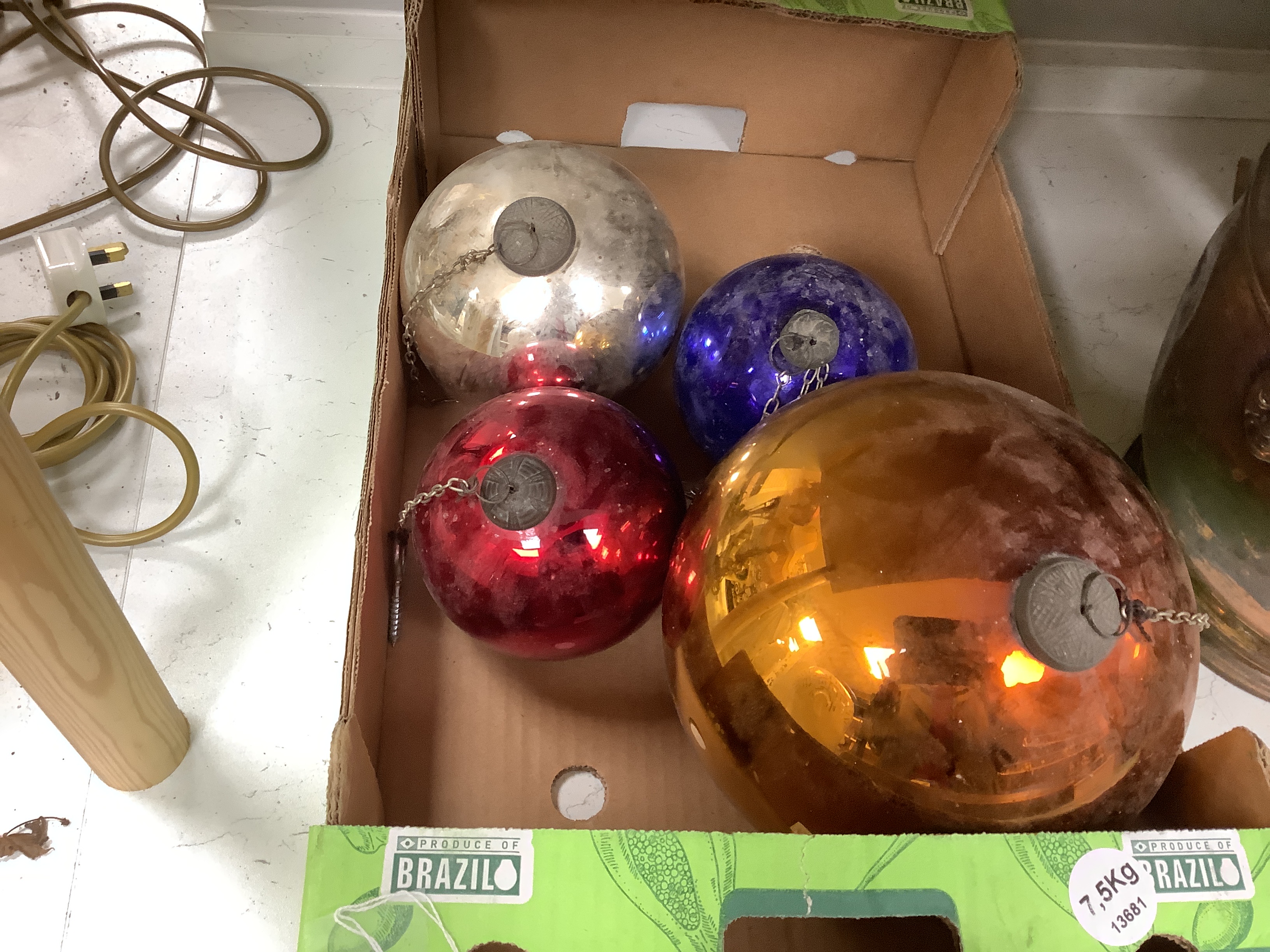 A gold witch’s ball and three small witch’s balls (silver, red and blue)